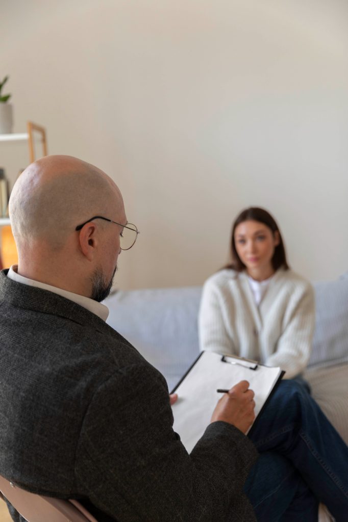 Neuropsychologue prenant des notes lors d'une évaluation neuropsychologique avec une patiente adulte en clinique privée à Montréal.