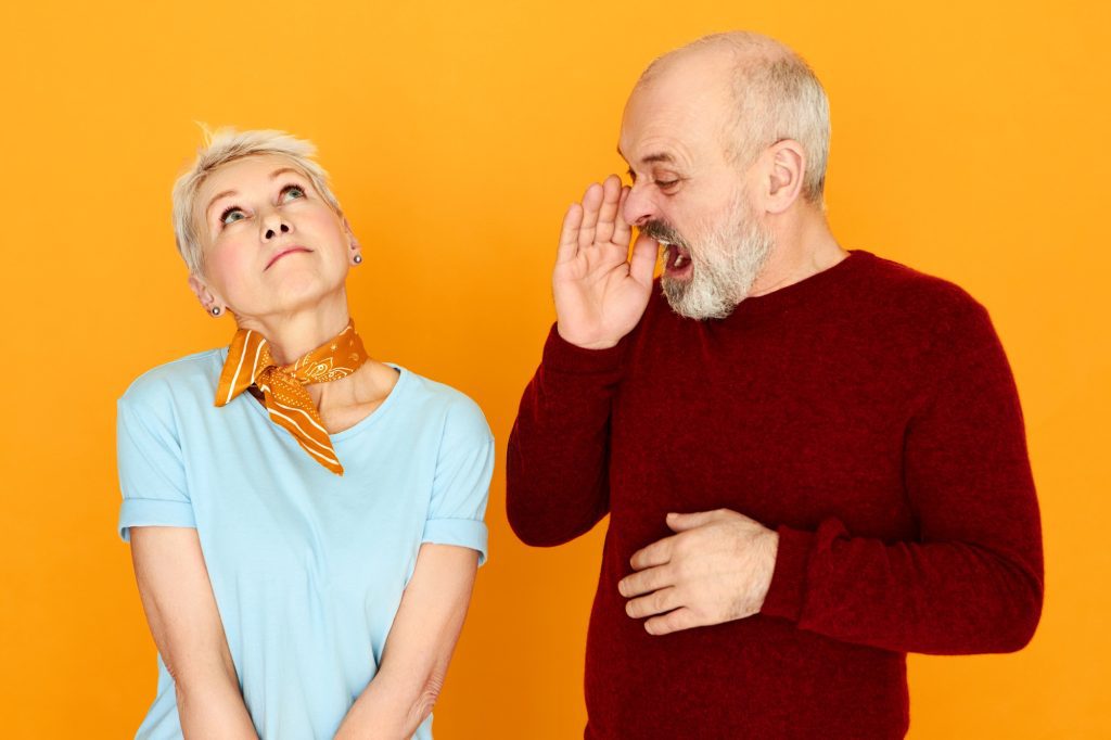 Homme âgé, la main en porte-voix, appelle une femme au regard absent : les signes de la dysphasie chez l'adulte passent souvent inaperçus.