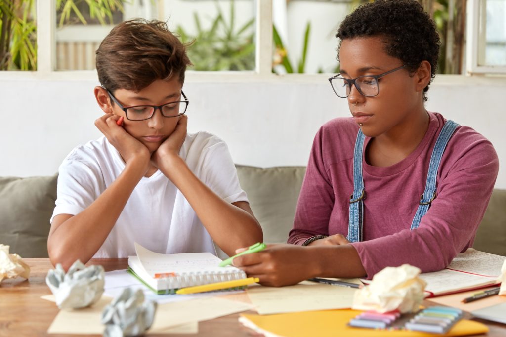 Adolescent avec TDAH ou TOP, découragé devant ses devoirs à la maison. 